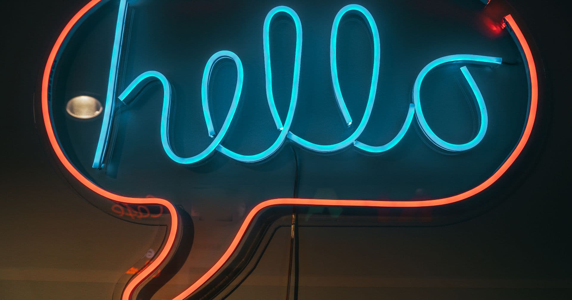 A neon speech bubble glowing with a hello message, evoking ChatGPT conversations