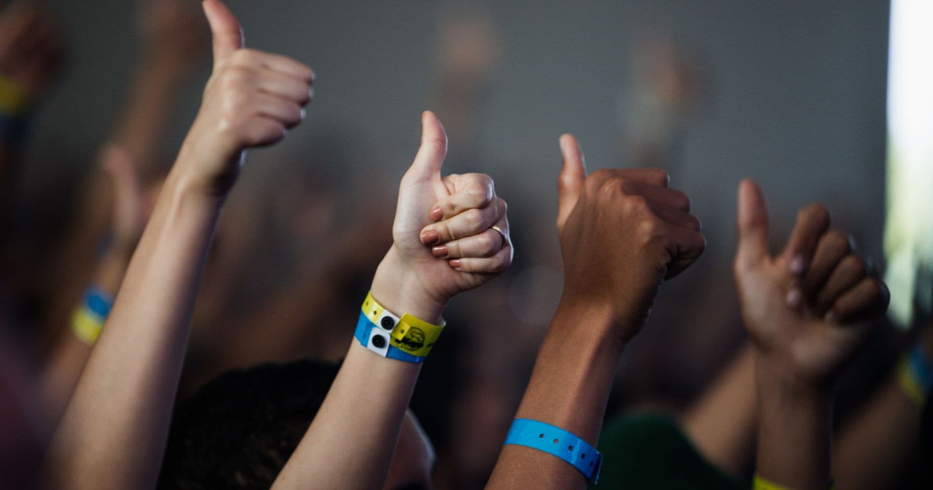 A group of diverse hands all giving a thumbs up — like backlinks acting as votes of confidence for a website