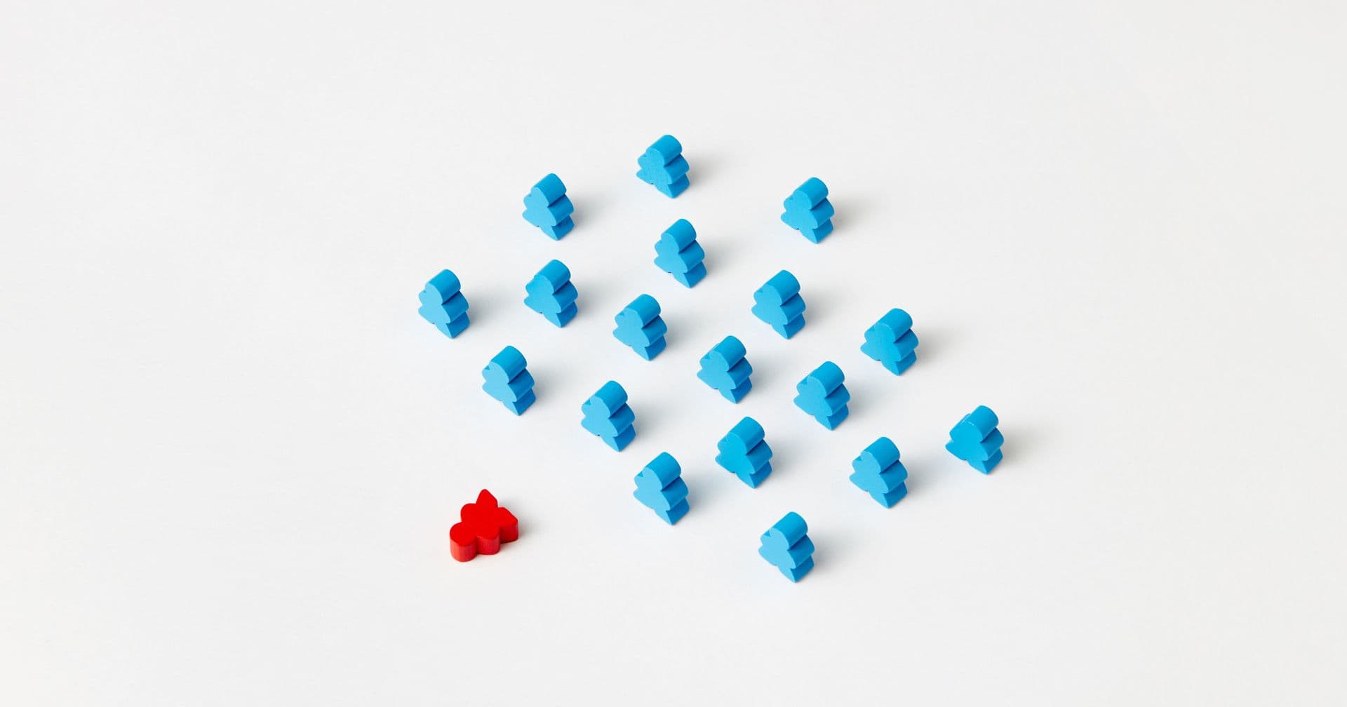 One red game piece standing out among identical blue pieces — like a canonical tag marking the original among duplicate URLs