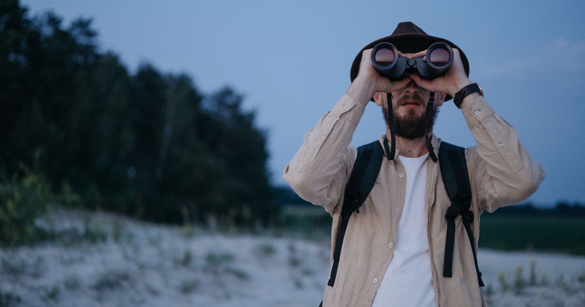 A person scanning the horizon through binoculars — like analysing competitors’ SEO strategy to outrank them