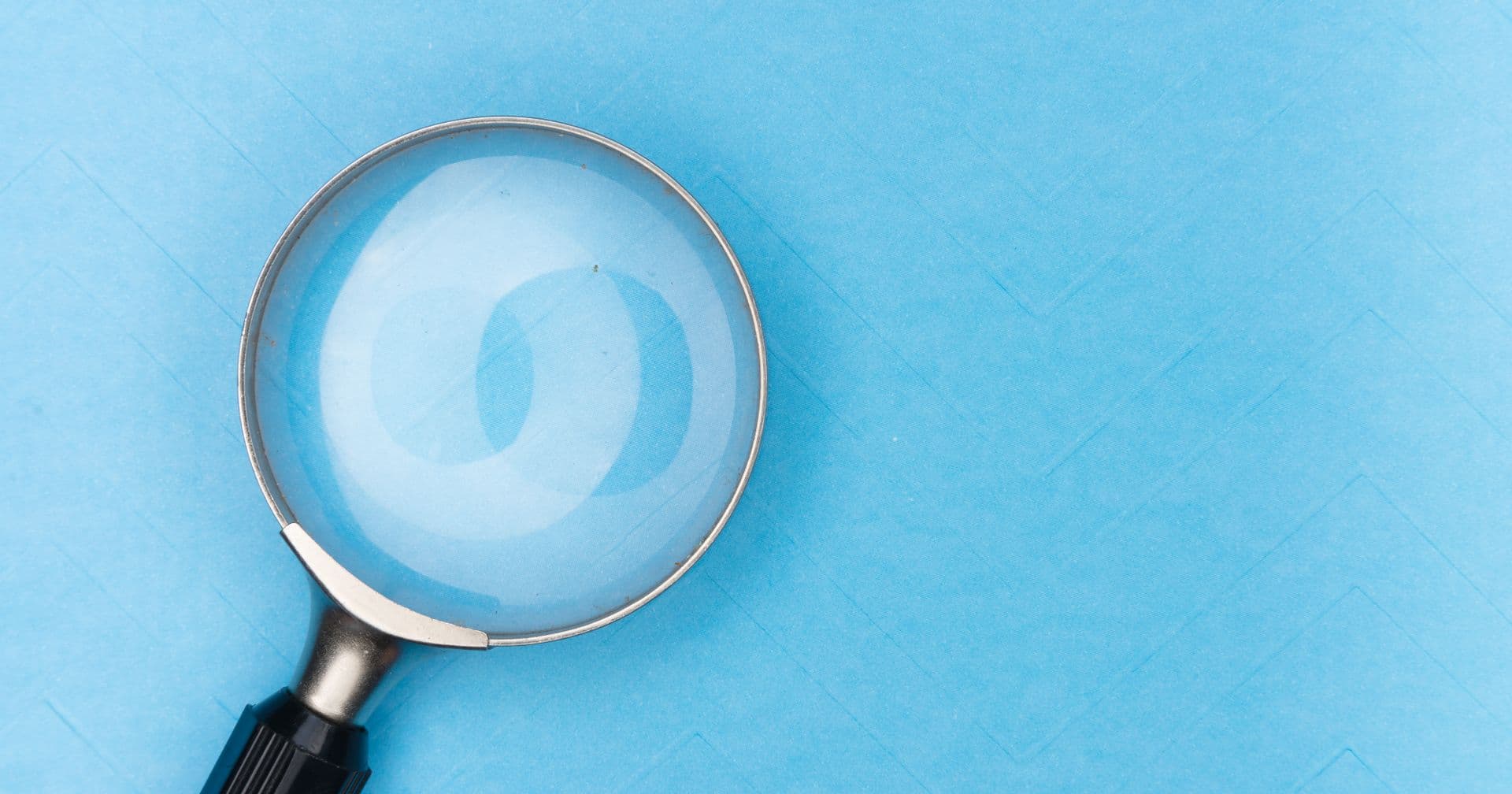 A magnifying glass held over a single key — like finding the keywords your audience searches for