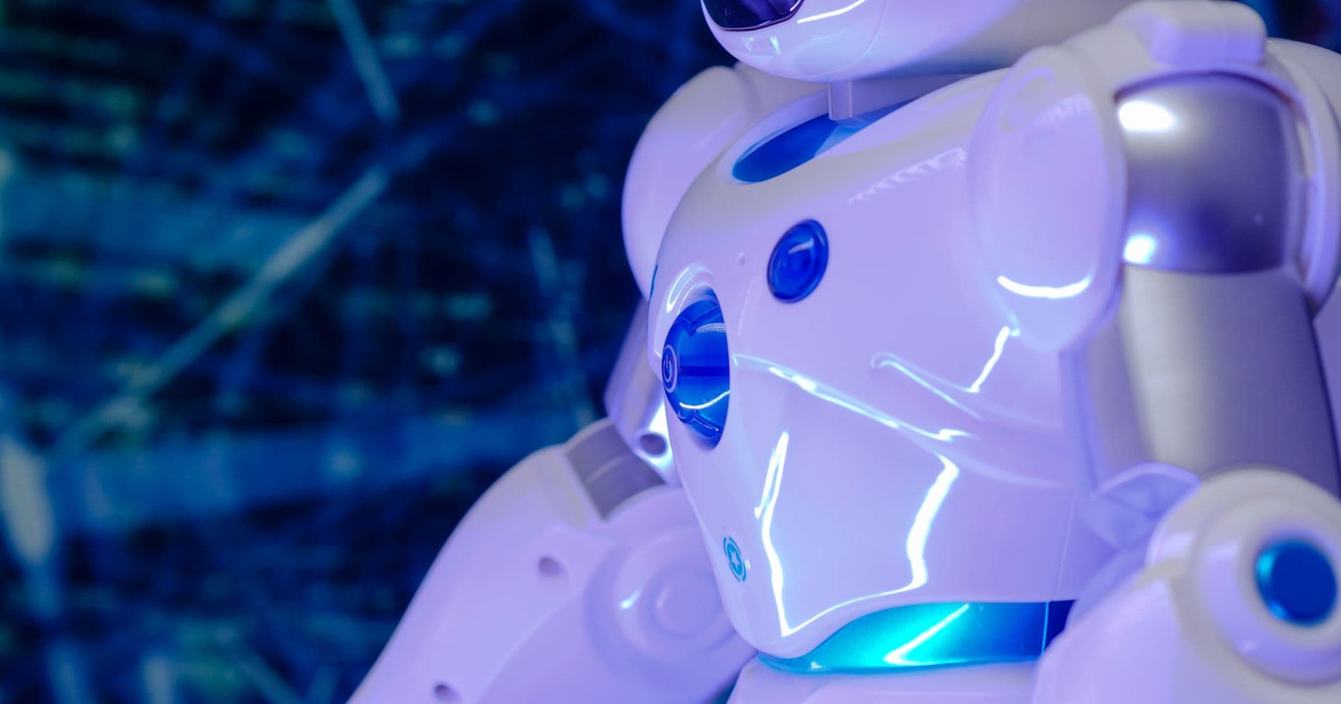 A friendly glowing white-and-blue humanoid robot — like optimizing your content for the AI answer engines that read and cite it